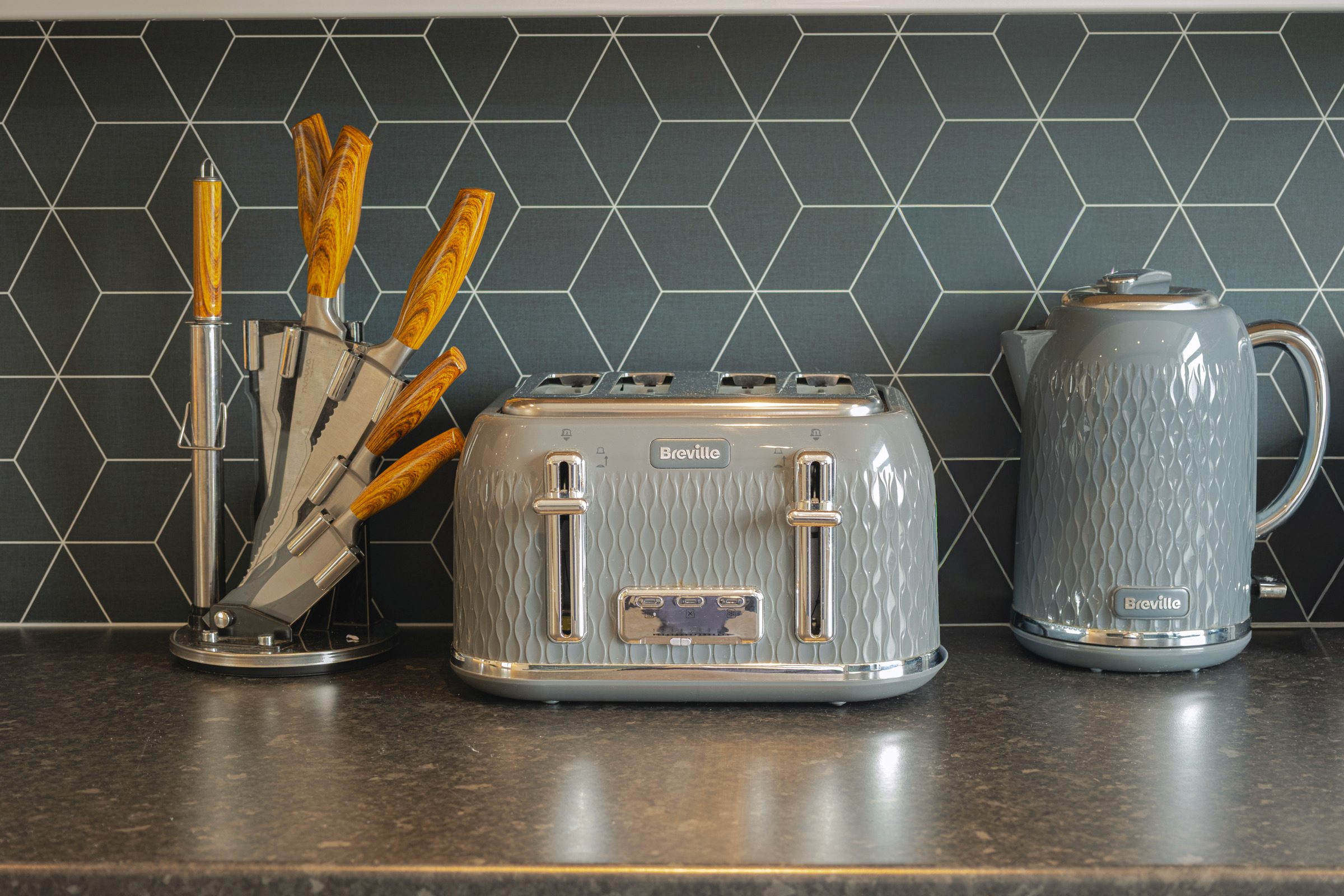 Toaster, kettle and knife block on the wood kitchenette worktop.