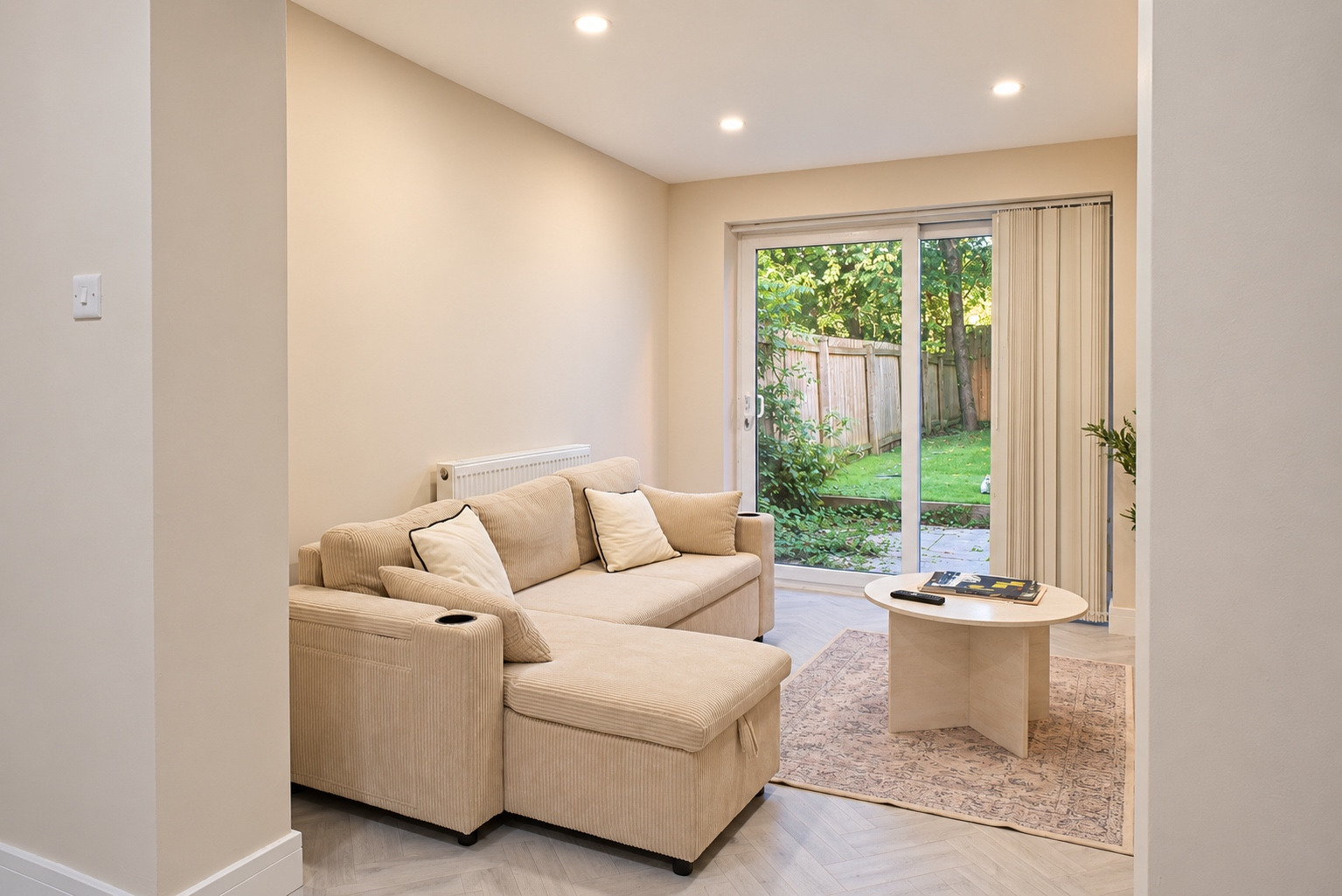 Cream corner sofa, round tables and garden doors in a bright contemporary lounge.