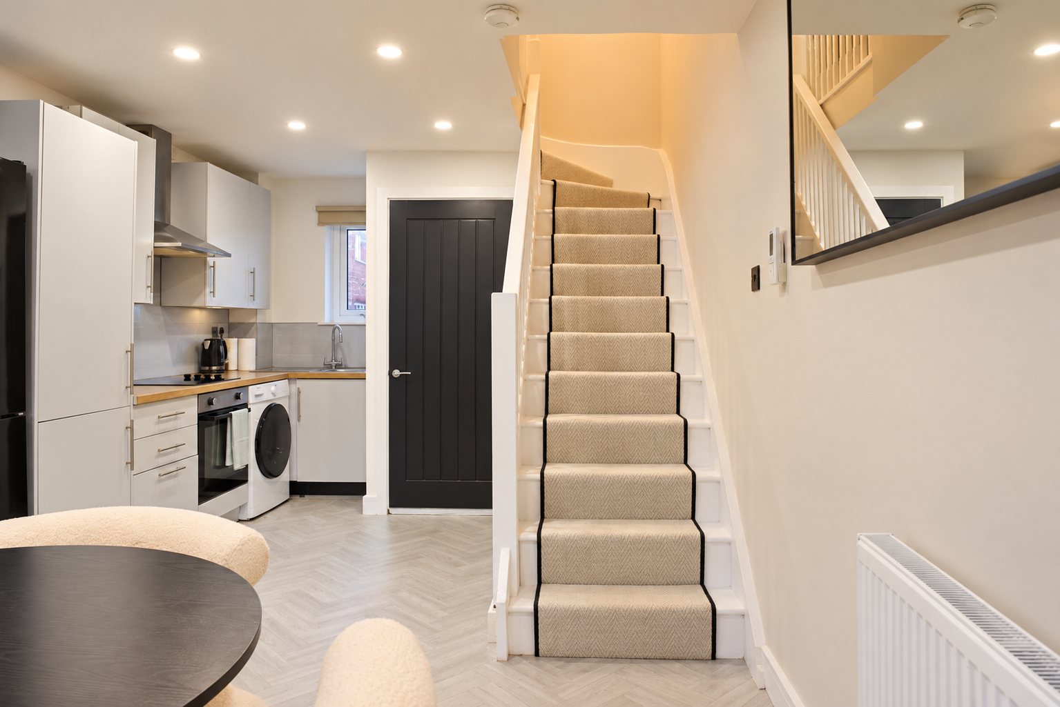 A carpeted stairway beside the kitchen, seen from the adjoining dining space.