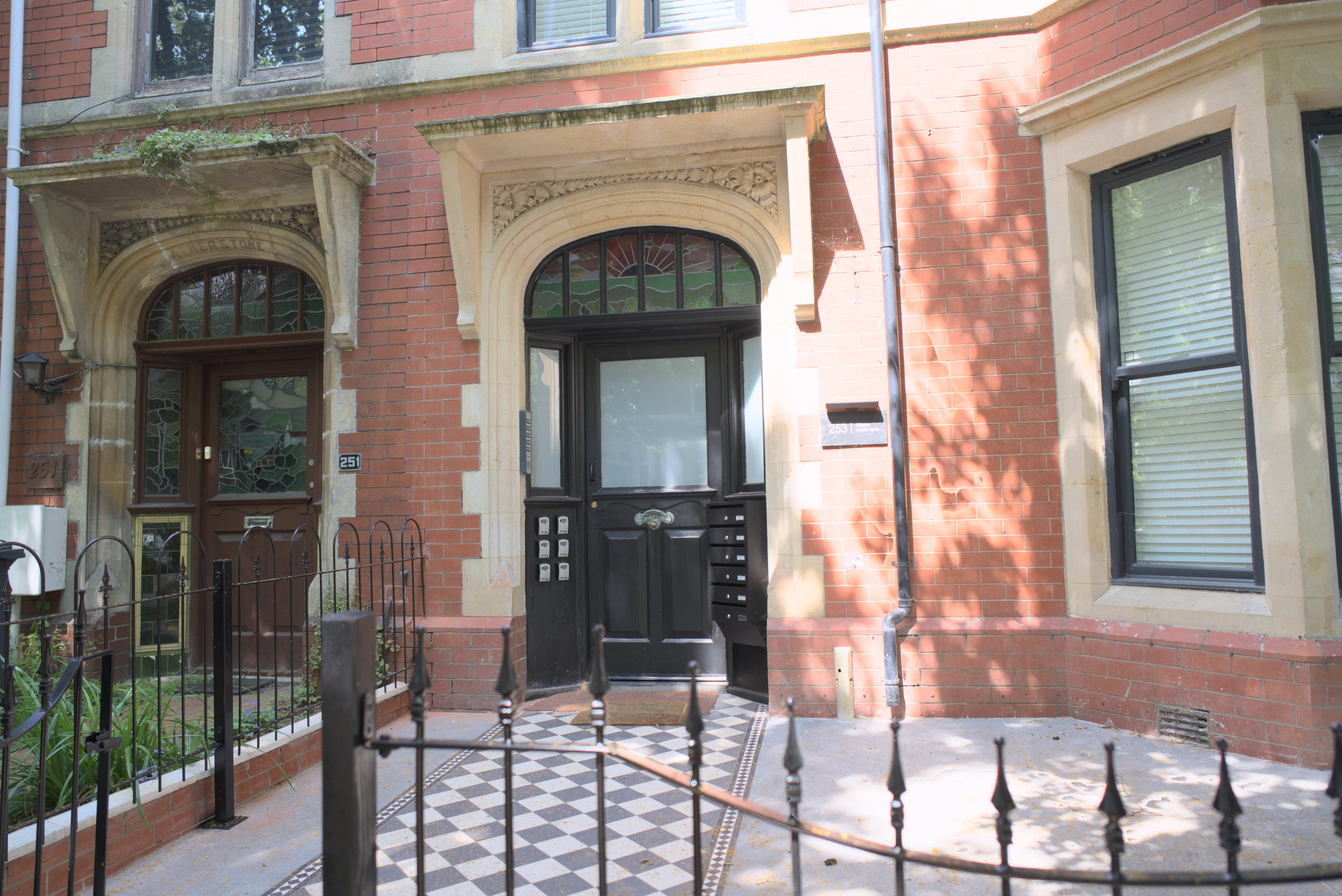 Red-brick period property with an arched entrance and tiled approach.