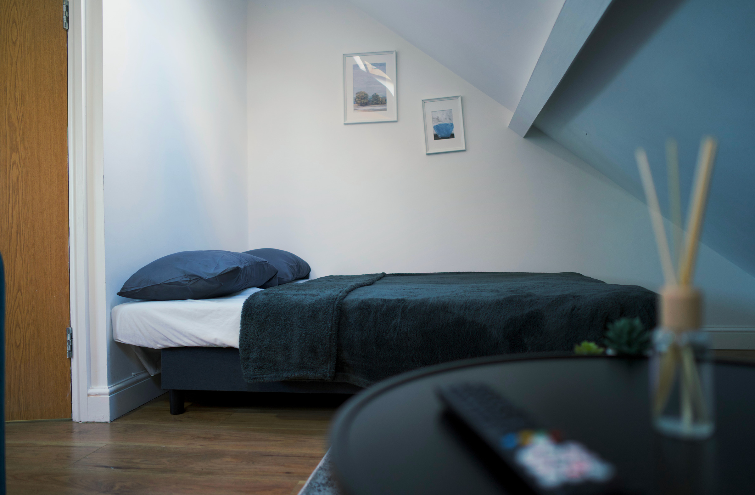 A made-up sleeping space beneath the apartment sloping ceiling.