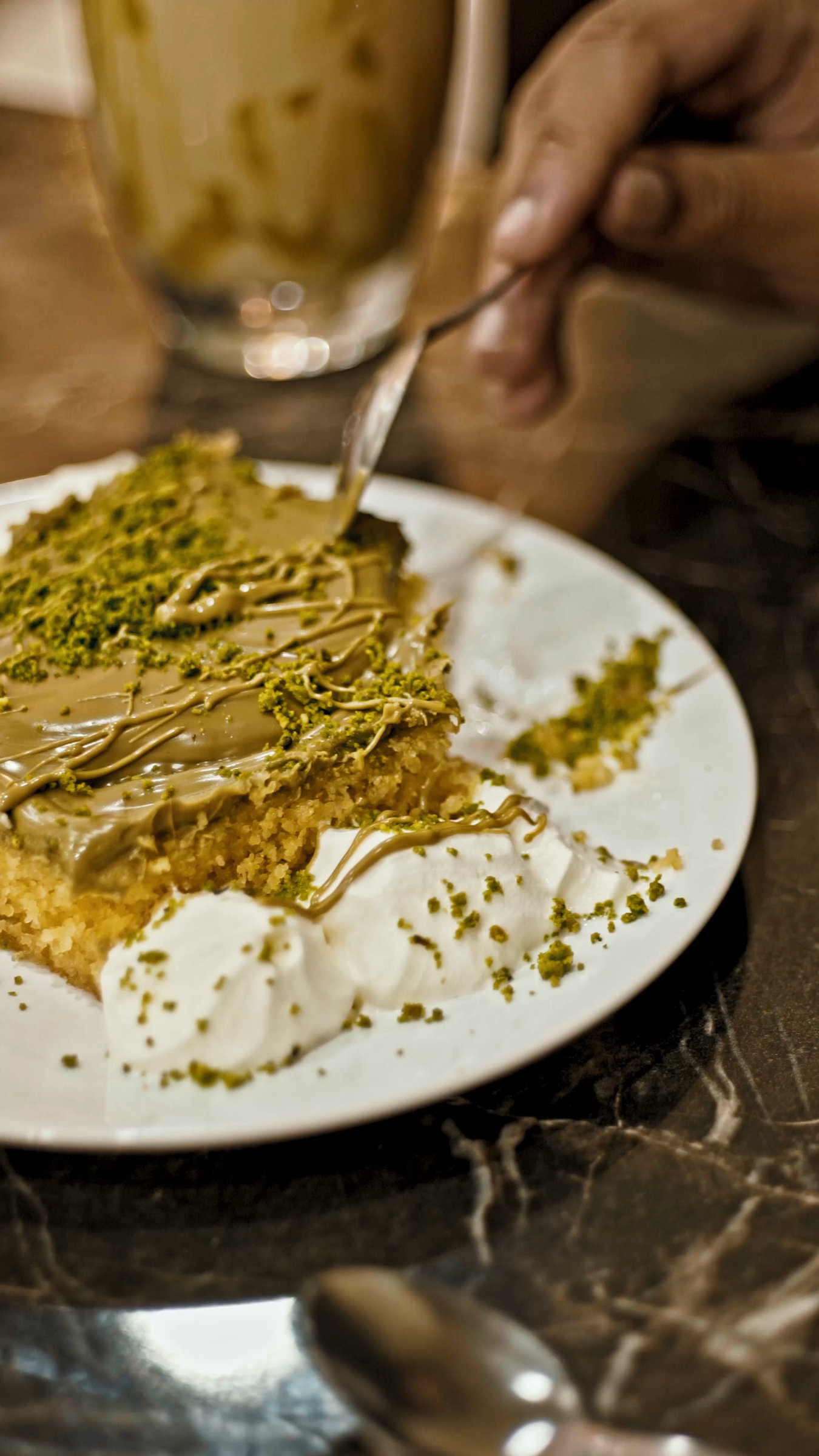 A close film frame of a green dessert and a hand holding a spoon.
