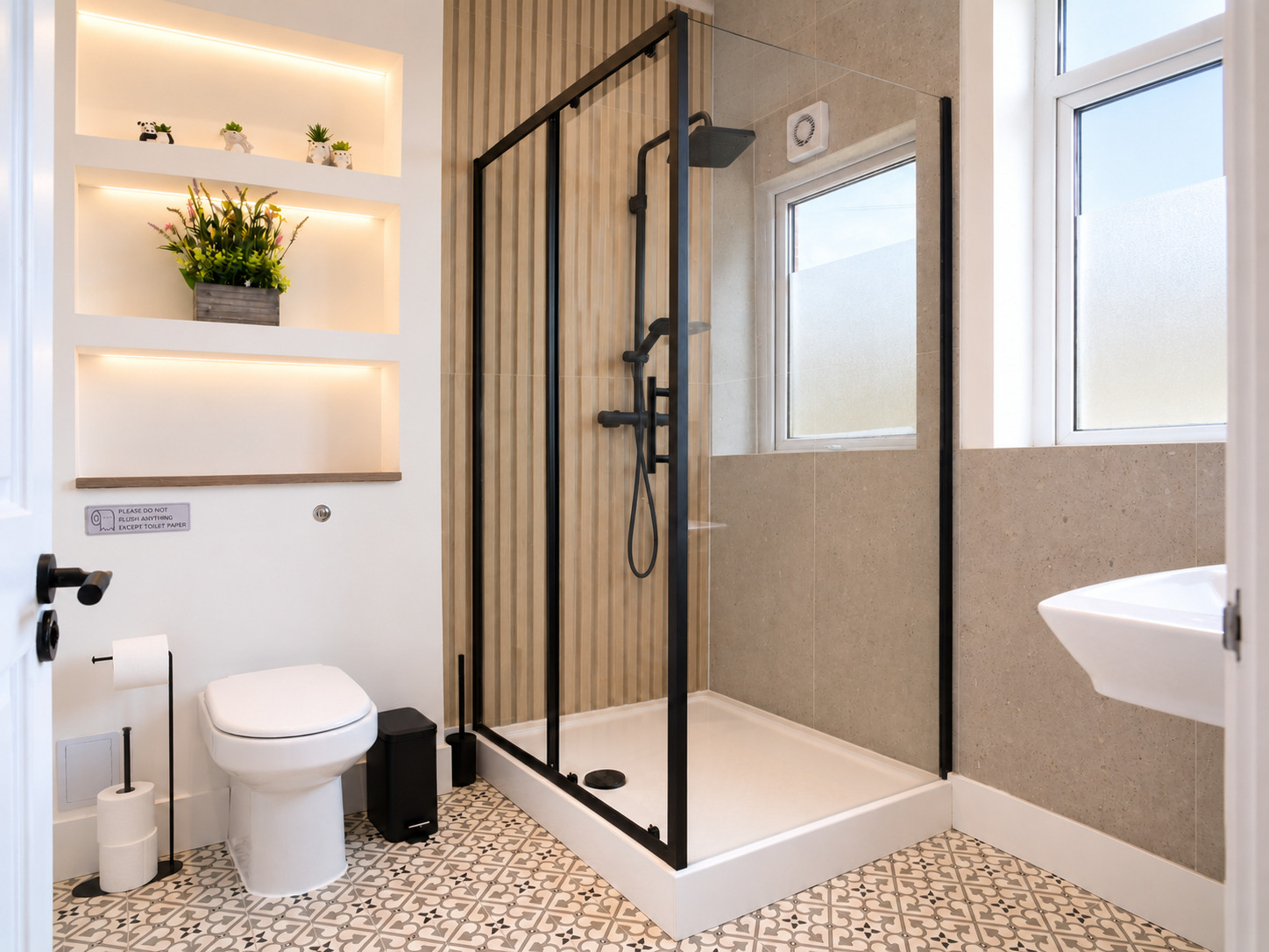 Glass shower enclosure, timber-slat feature and white toilet in a compact bathroom.
