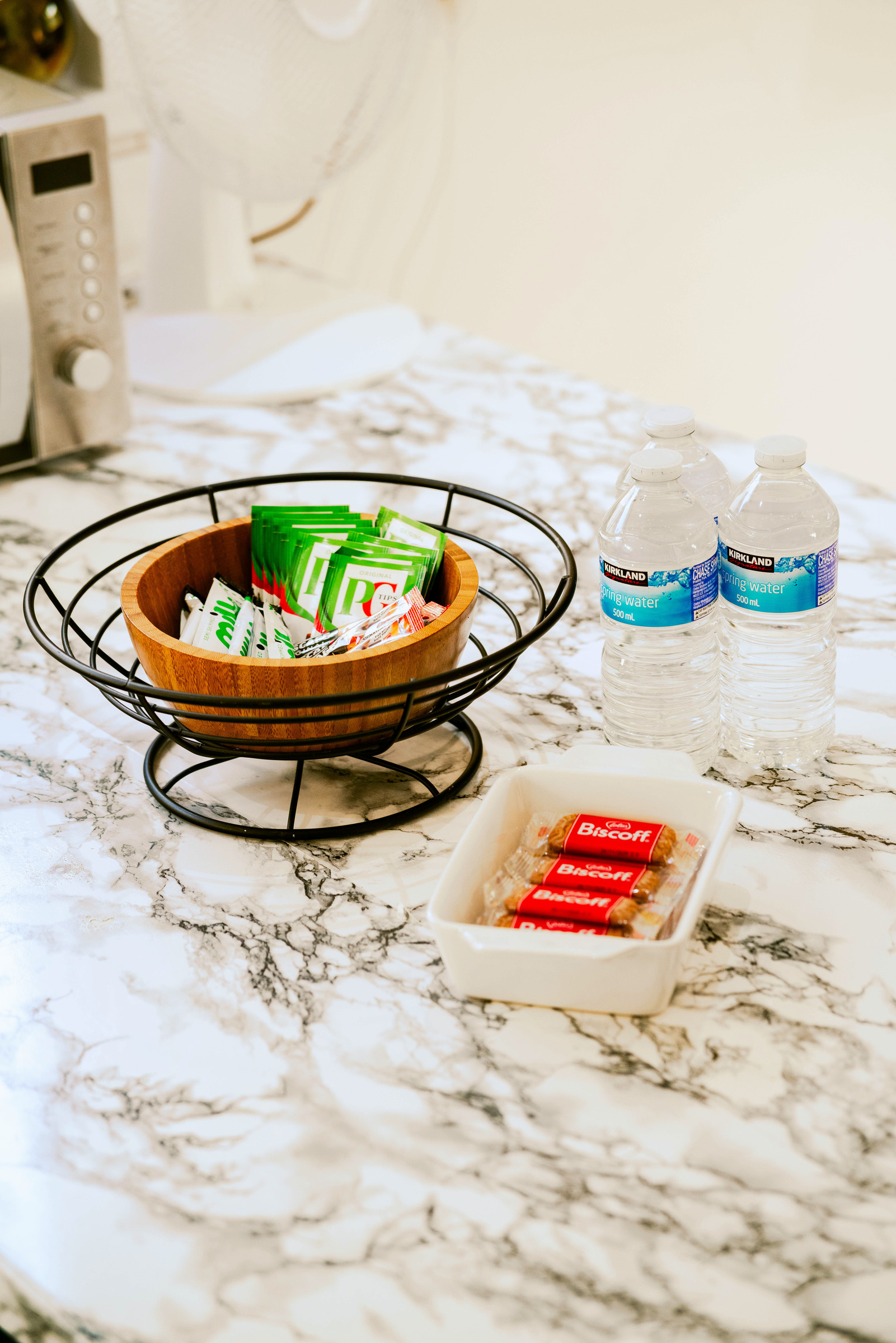 Fruit bowl, drinking glasses and small dishes on the marble-pattern kitchen counter.